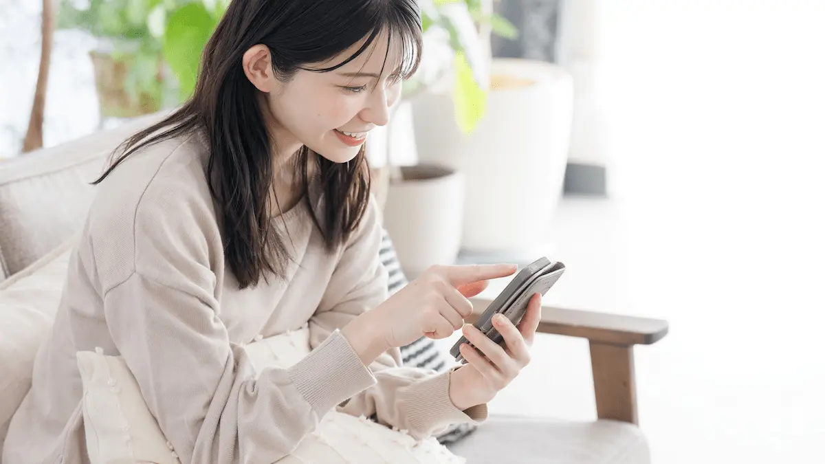 笑顔でスマホを見る女性